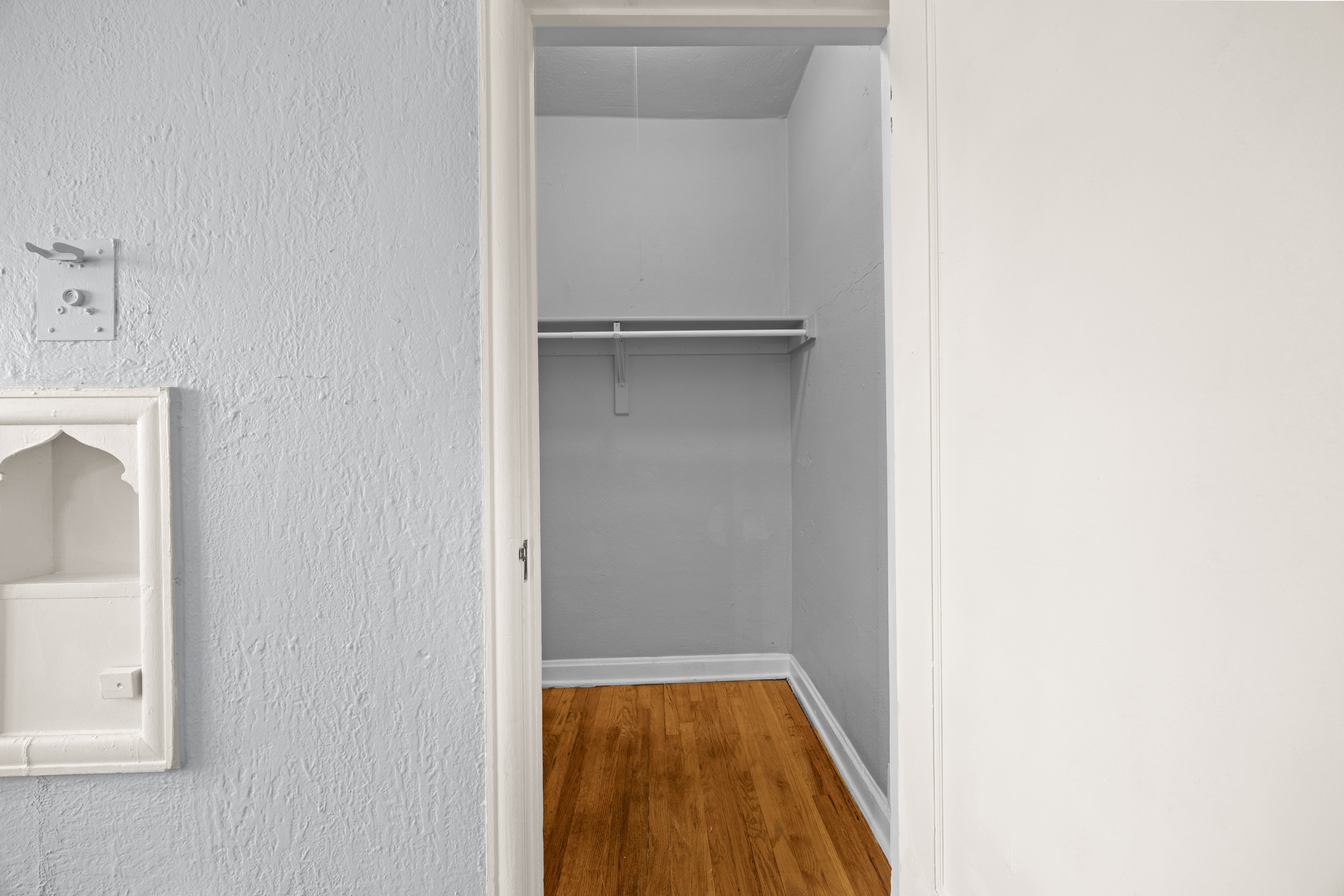 A room with a ceiling fan and wooden floors.